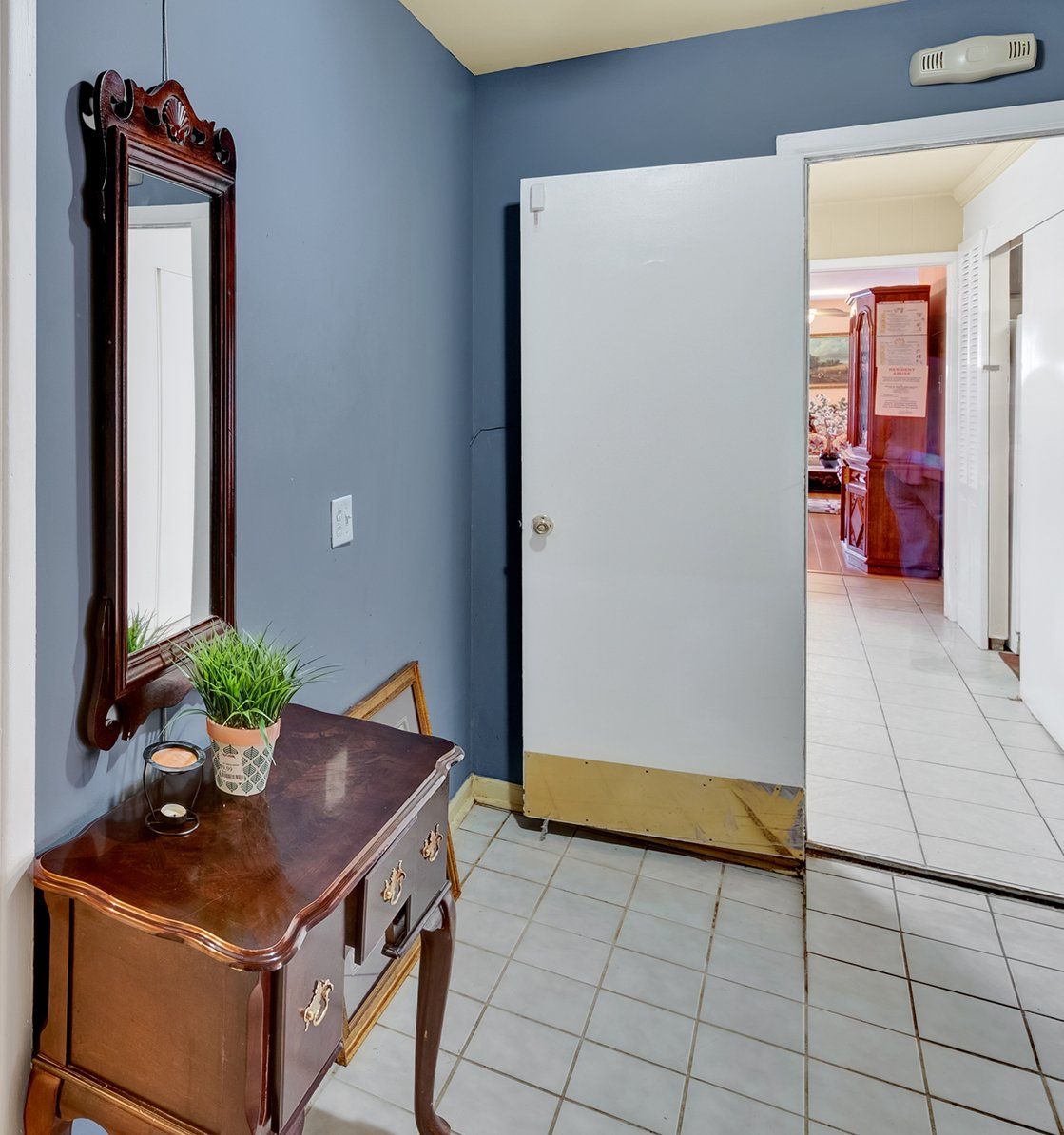 A hallway with a wooden table and a mirror