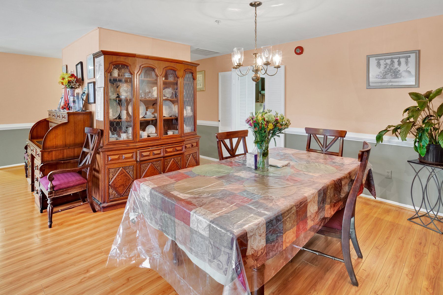 A dining room with a table and chairs and a hutch.