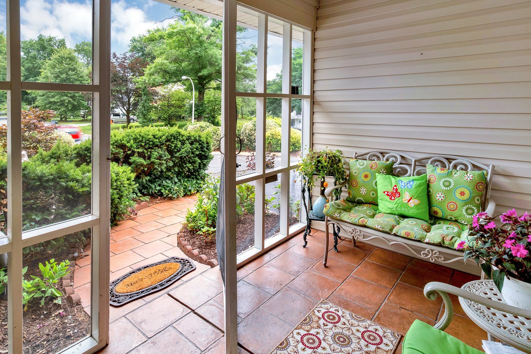 A screened in porch with a couch and chairs