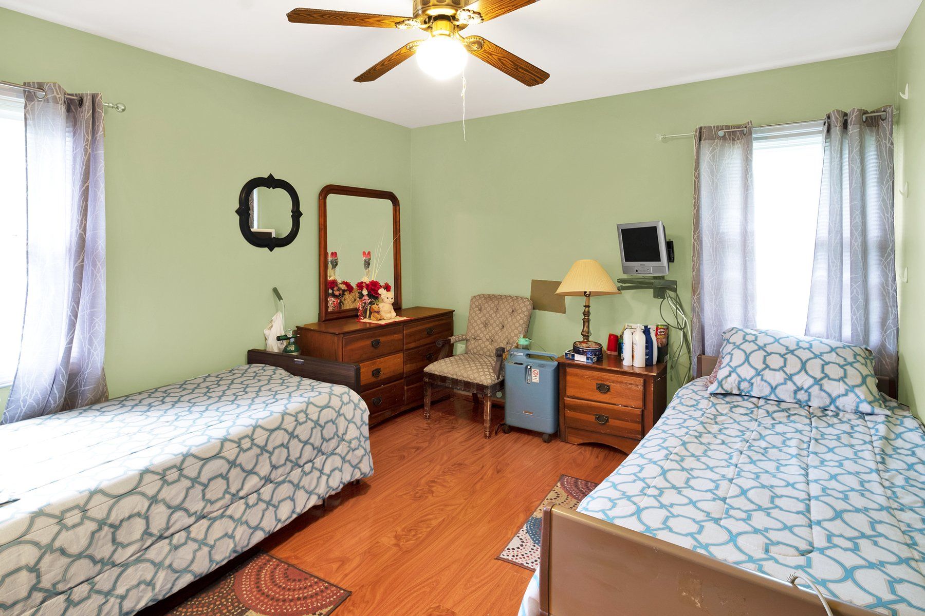 A bedroom with two beds and a ceiling fan.