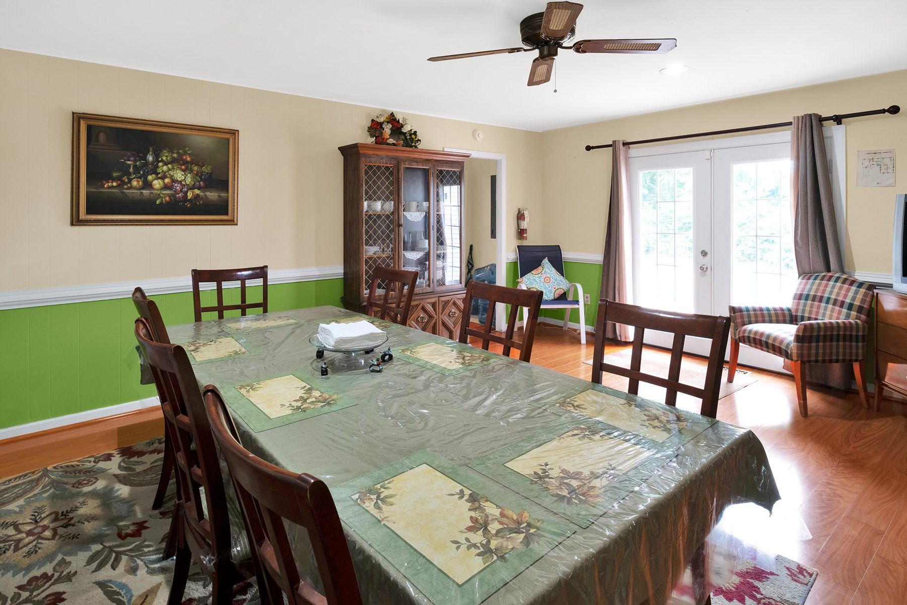 A dining room with a table and chairs and a ceiling fan.