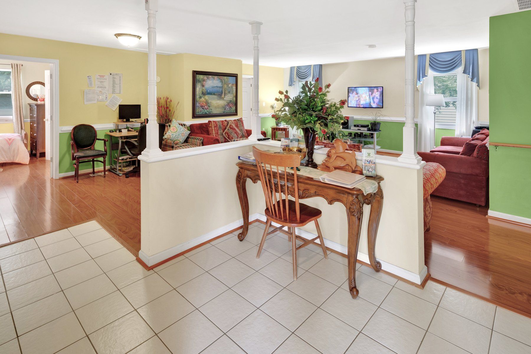 A living room with a desk and chair in the middle