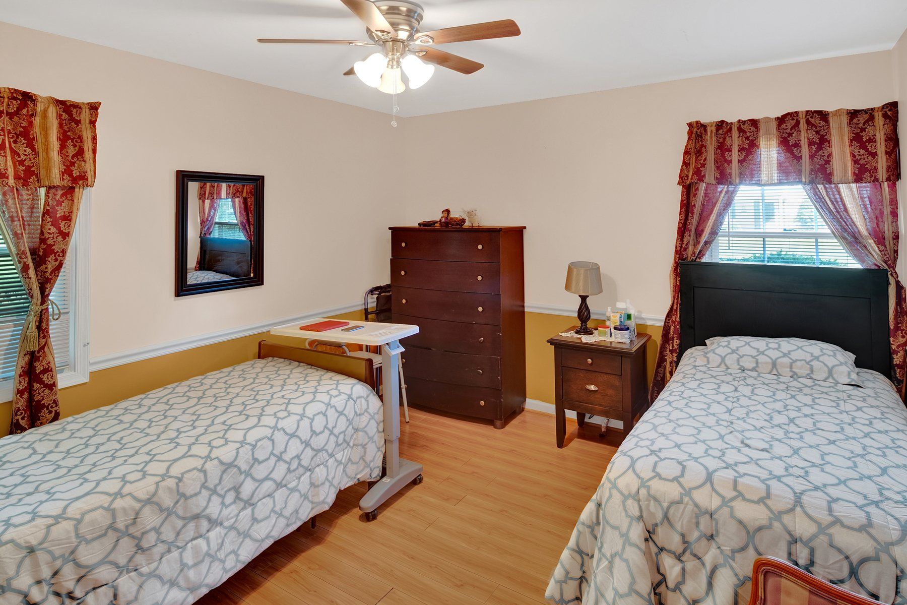 A bedroom with two beds and a ceiling fan