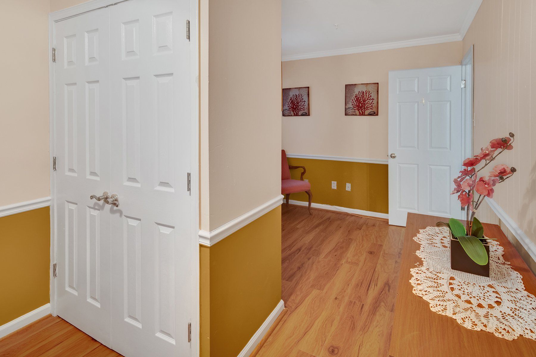 A hallway with hardwood floors and a white door