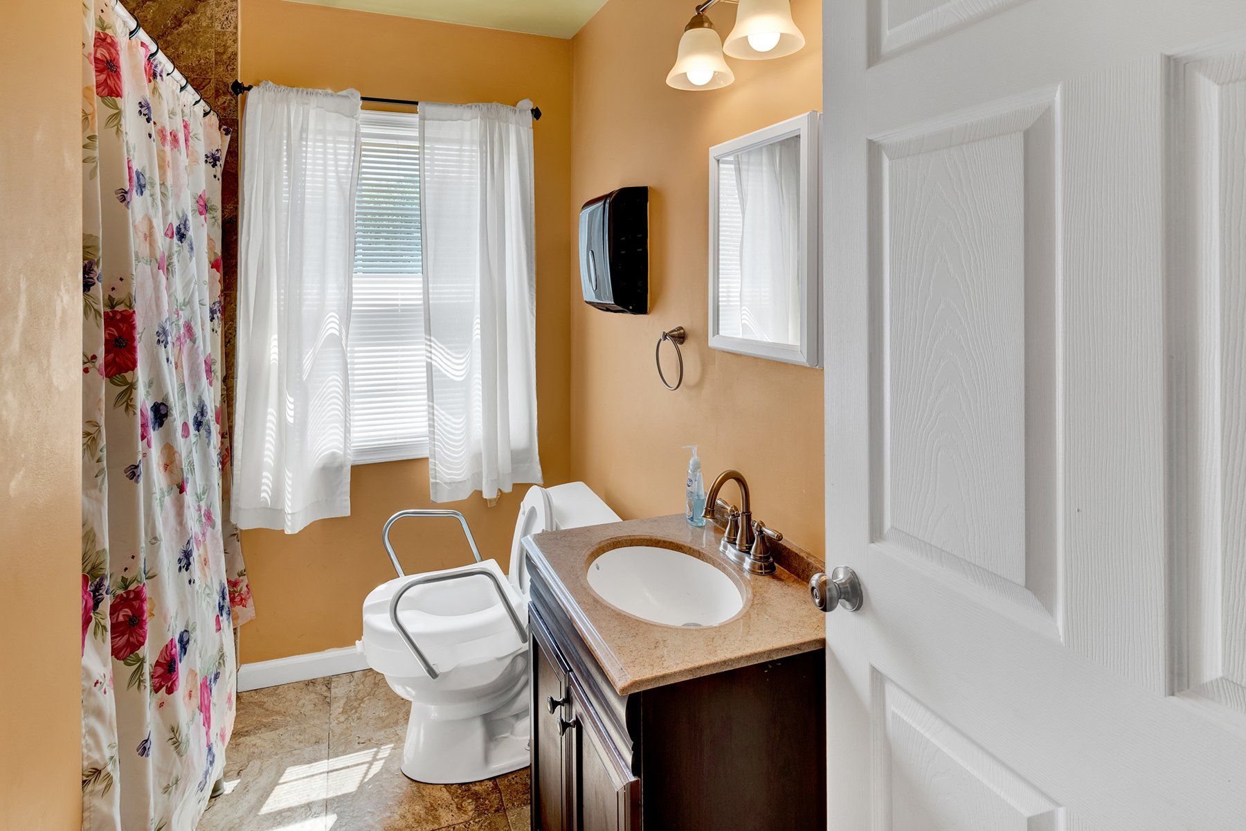 A bathroom with a toilet , sink , and shower curtain.