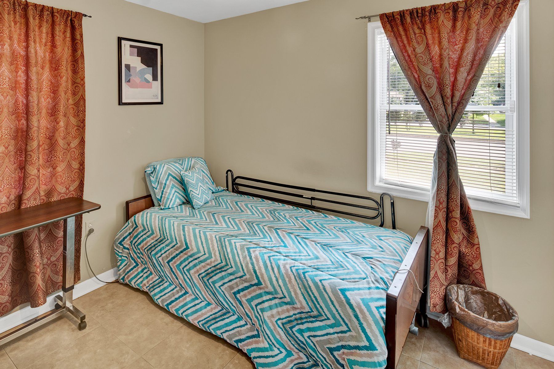 A bedroom with a bed and a window with curtains.