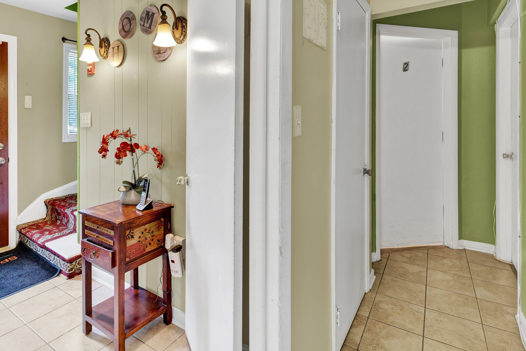 A hallway in a house with a table and a mirror.