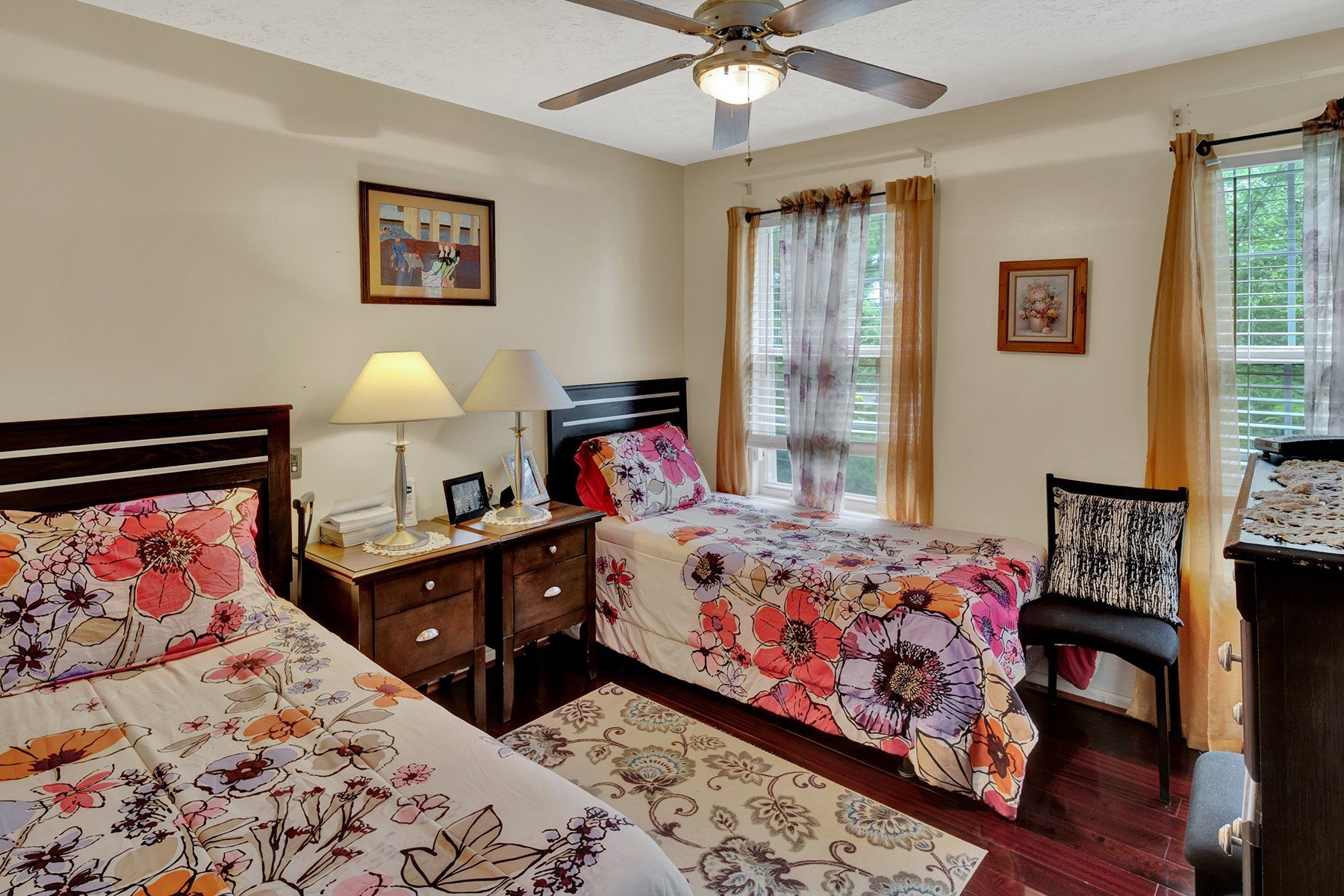 A bedroom with two twin beds and a ceiling fan
