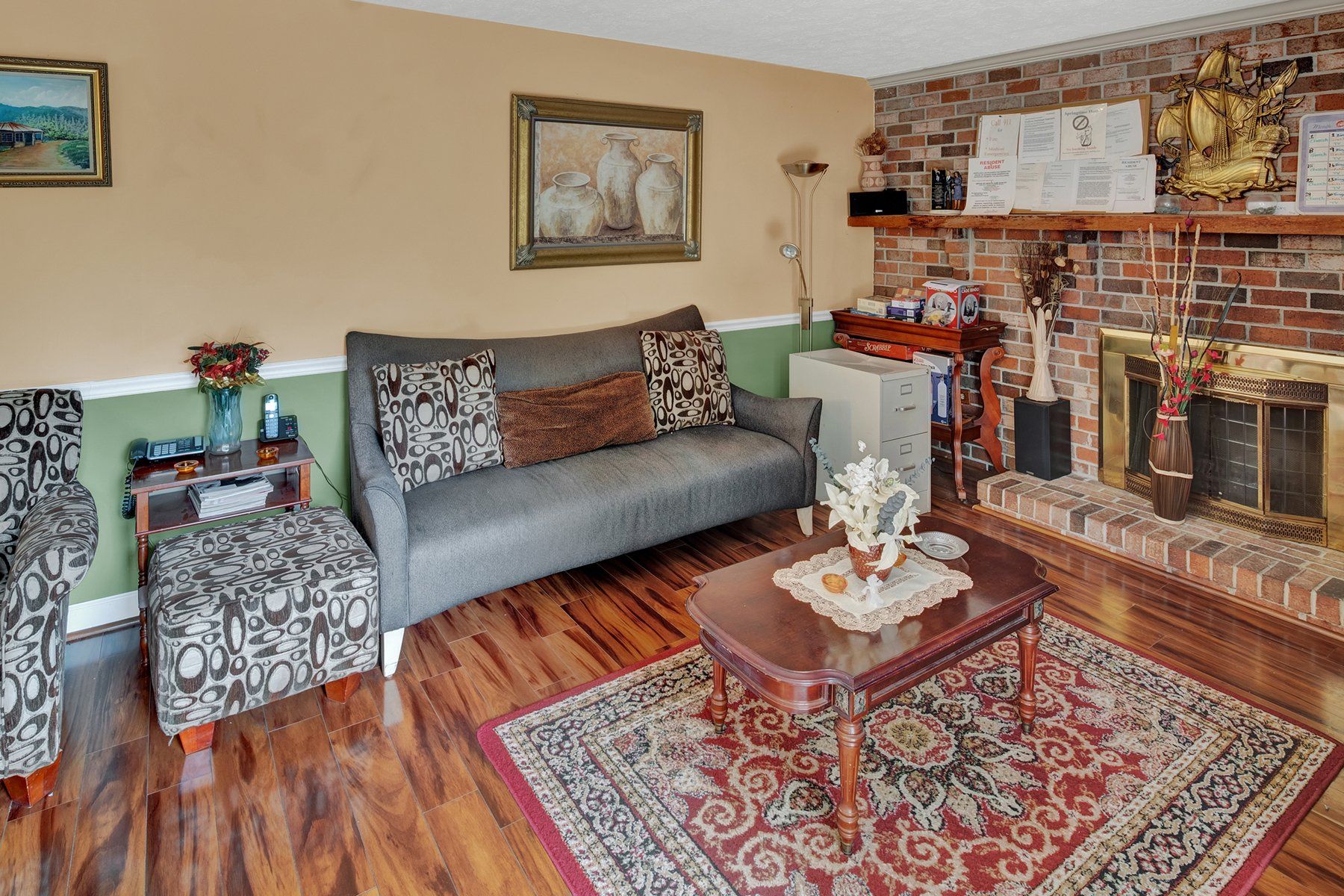 A living room with a couch , chairs , coffee table and fireplace.