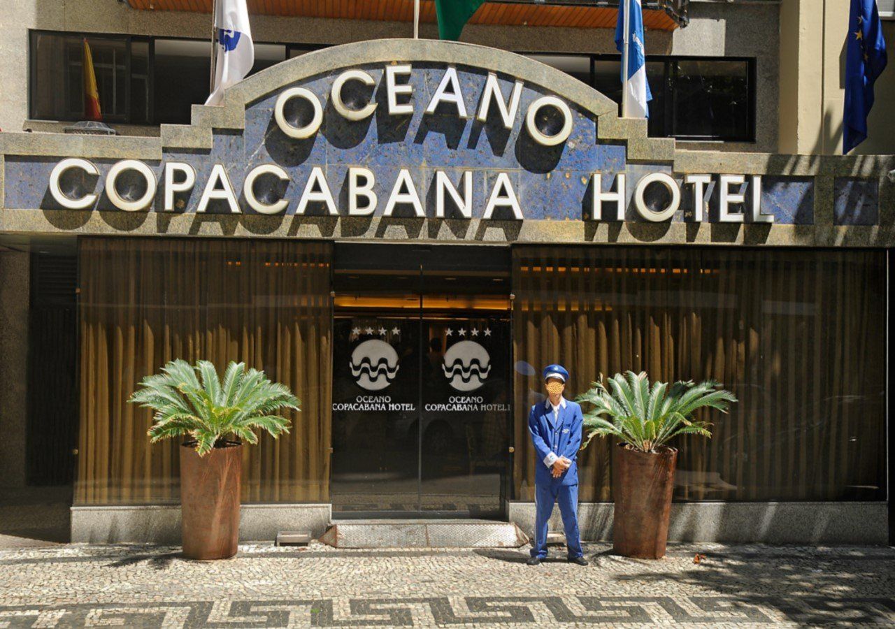 Um homem está parado em frente ao hotel oceano copacabana