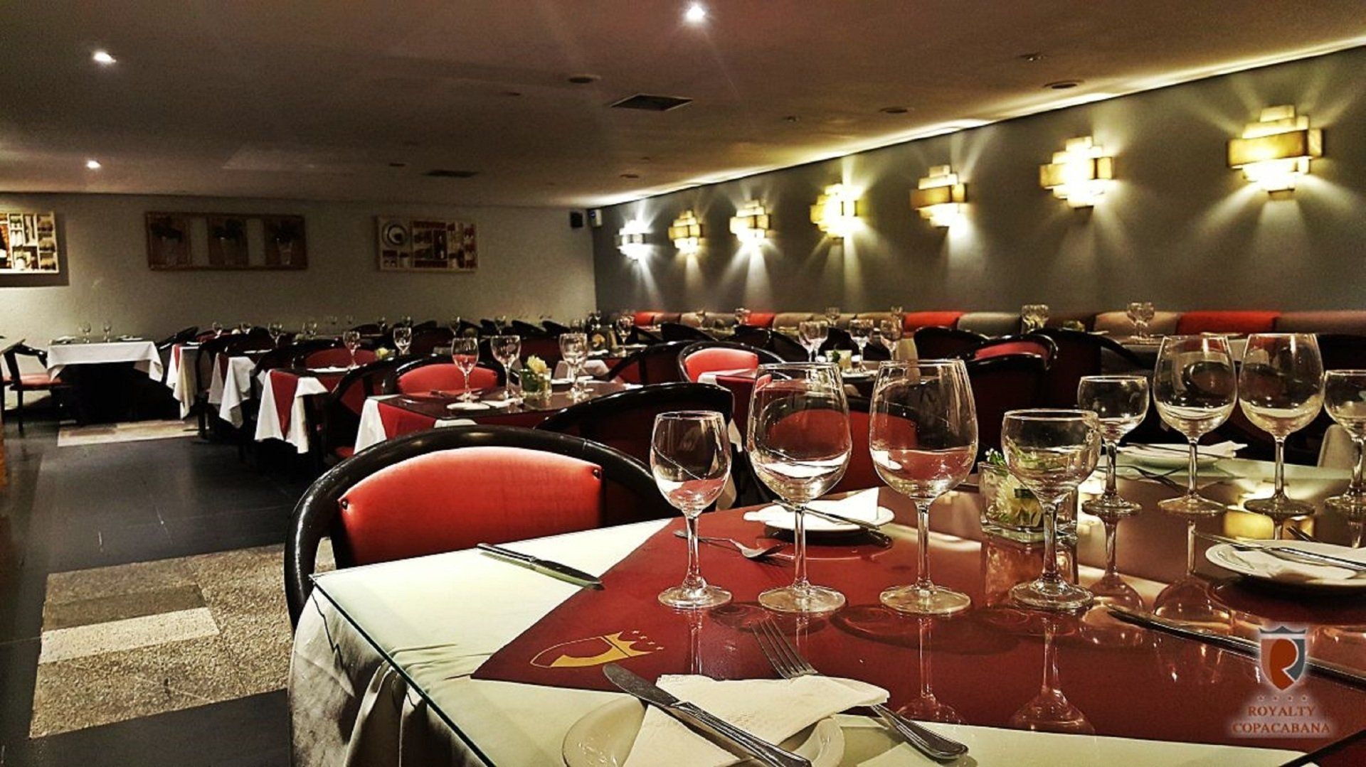 Um restaurante cheio de mesas e copos de vinho
