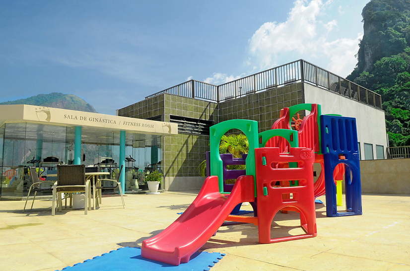 Um playground colorido com um escorregador em frente a um prédio