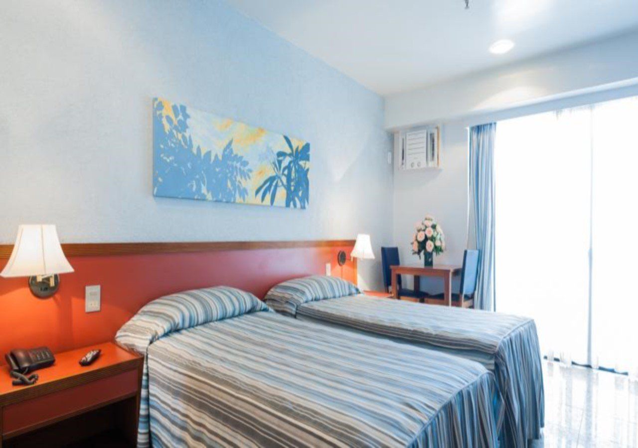 Um quarto de hotel com duas camas e uma pintura na parede