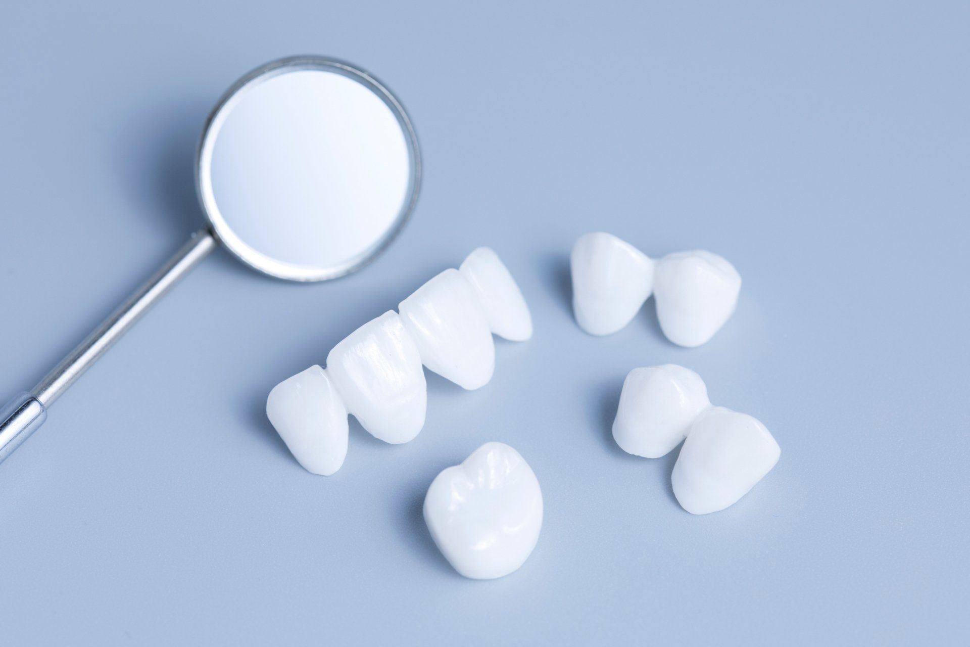 Porcelain — Porcelain Veneers On Light Blue Background in Henderson, NC Porcelain — Porcelain Veneers On Light Blue Background in Henderson, NC
