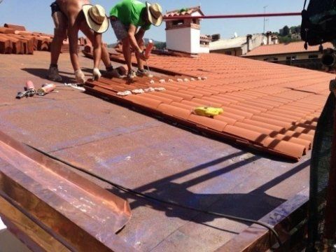 due operai durante lavori di ristrutturazione di un tetto