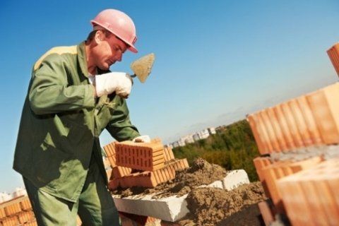 operaio durante la costruzione di un muro