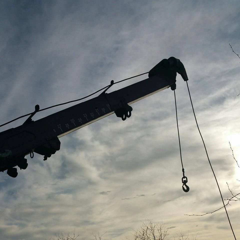 Silhouette of towing company truck arm and hook