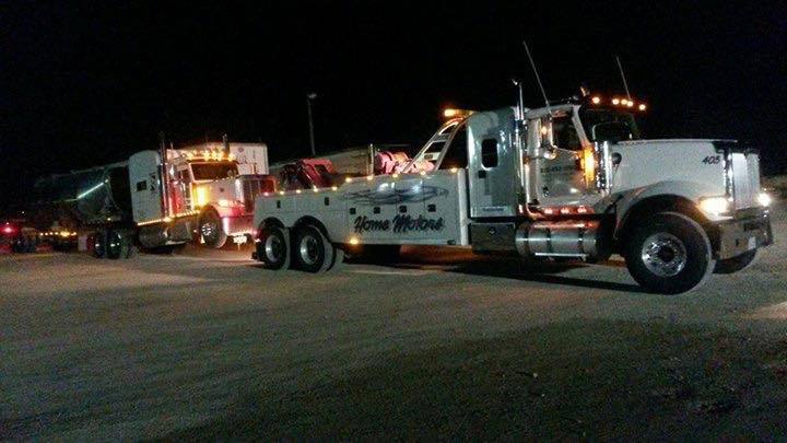 Home Motors, Inc tow truck service providing roadside assistance at night in Winters, TX