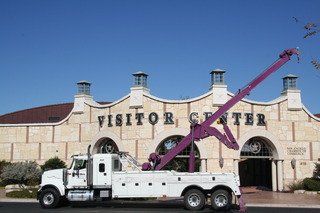 Home Motors, Inc tow truck service work truck parked outside a visitor center