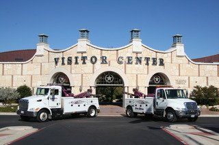 Home Motors, Inc tow truck service fleet vehicles parked outside a visitor center