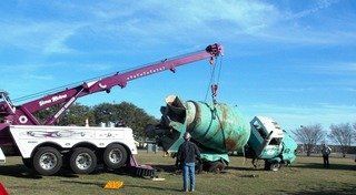 Home Motors, Inc fleet truck towing a cement truck in Big Lake, TX
