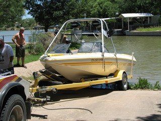 Towing company providing auto recovery assistance to pull a boat out of the water in Big Lake, TX