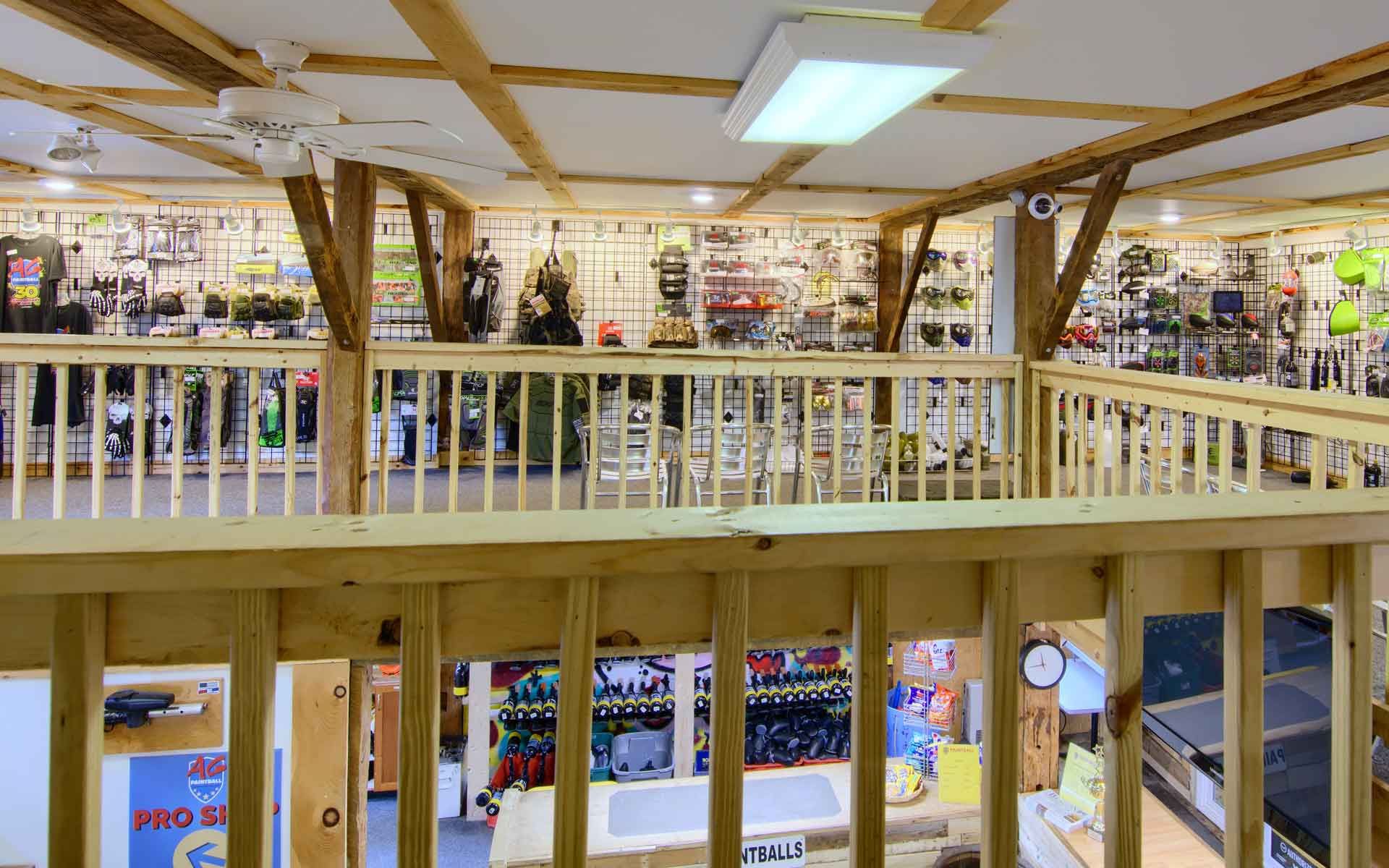 Two-story retail space with wooden beams, railings, and merchandise displays.