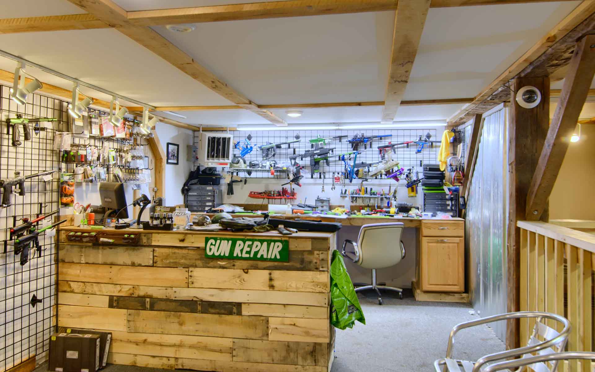 Gun repair shop with tools, workbenches, and a wooden counter.