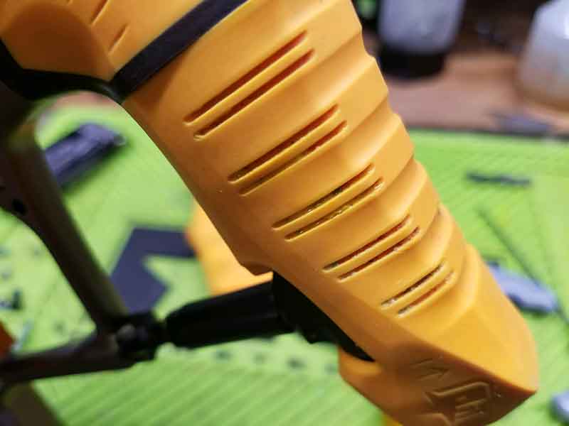 Yellow and black drone component with ribbed texture and ventilation slits.