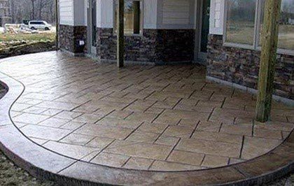 Stamped concrete patio with a curved edge and stone accents.