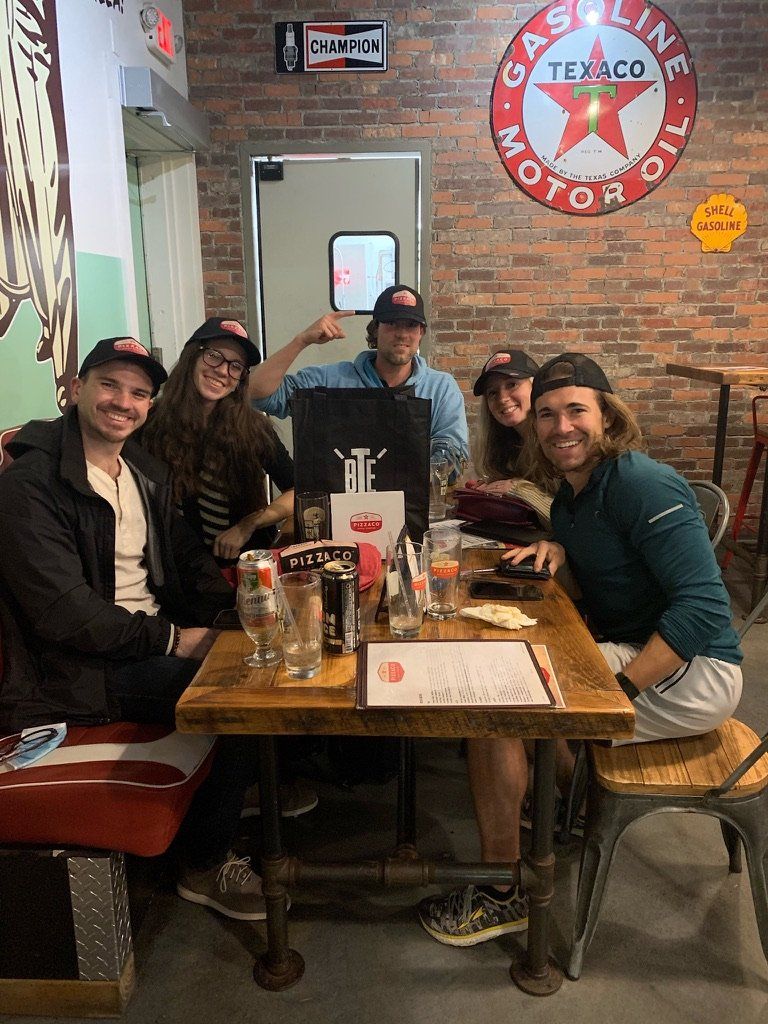 Group of people at a restaurant table with a Texaco sign.