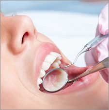 Dental exam being done on a woman to see if she needs Periodontal Treatments by Nassau County Periodontist, Dr. Marichia Attalla in Williston Park, NY 11596