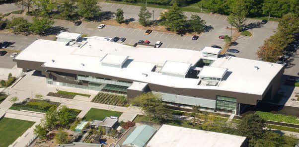 An aerial view of a large building with a white roof