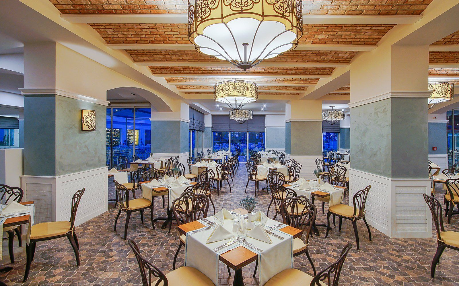 A large dining room with tables and chairs and a chandelier.