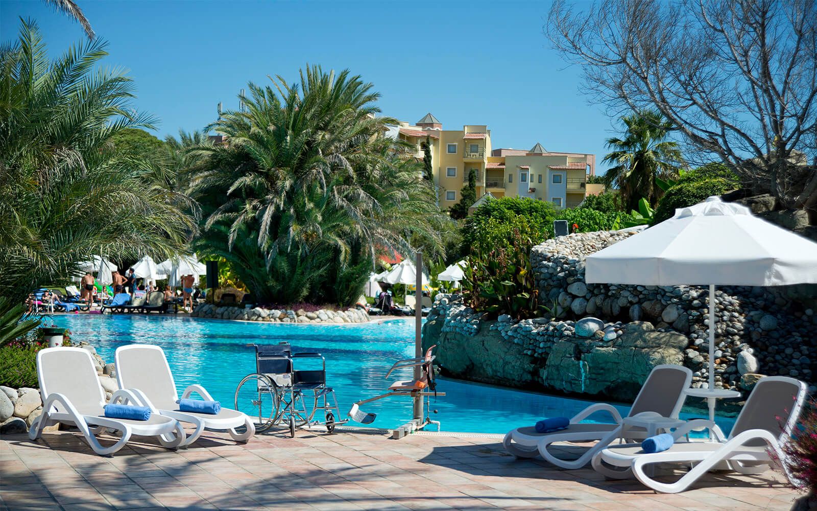 Ein großer Swimmingpool, umgeben von Stühlen und Sonnenschirmen.