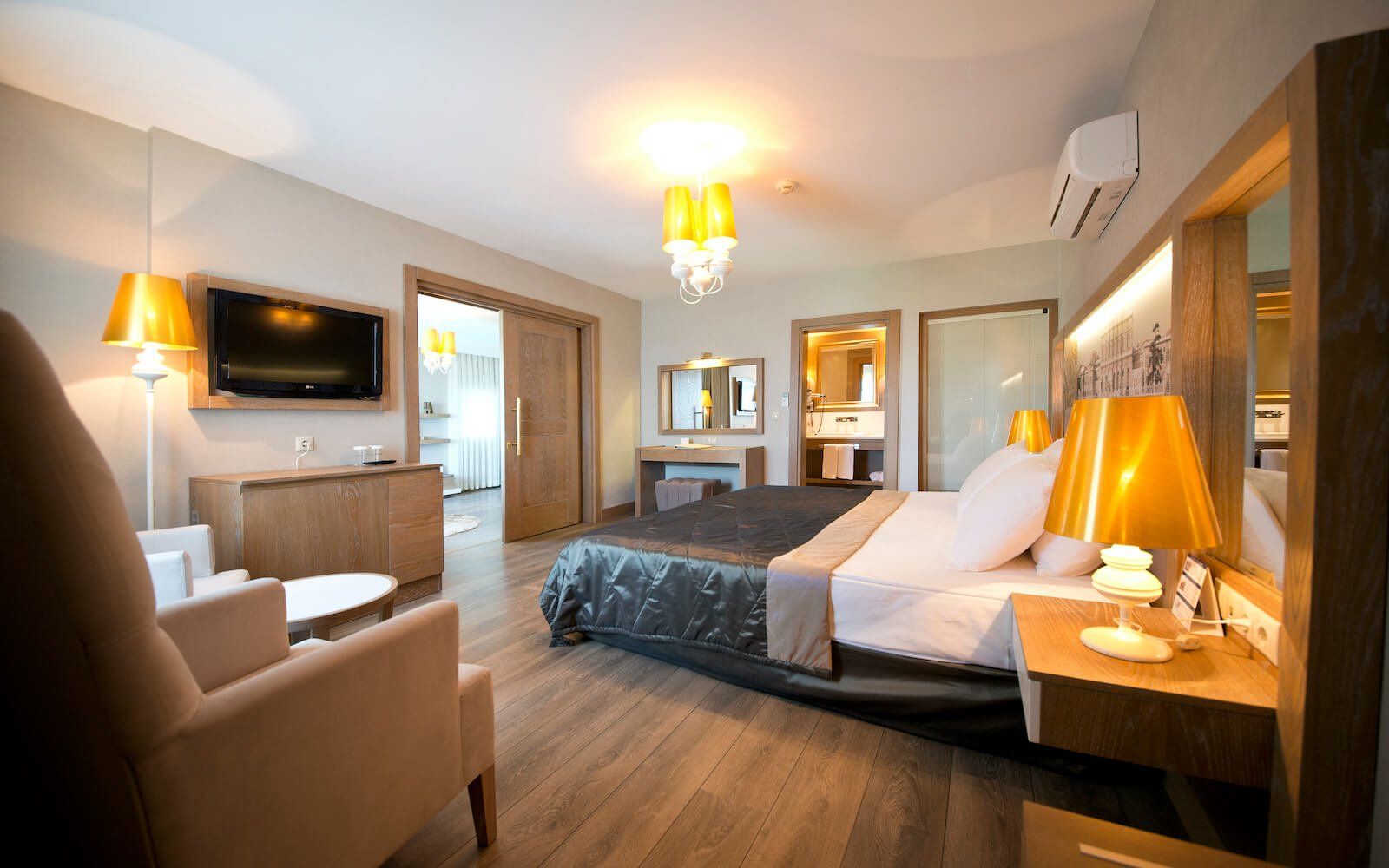 Ein Hotelzimmer mit großem Bett, Stuhl, Tisch und Fernseher.