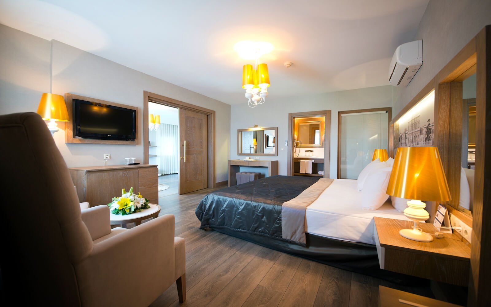 Ein Hotelzimmer mit großem Bett, Stuhl, Tisch und Fernseher.