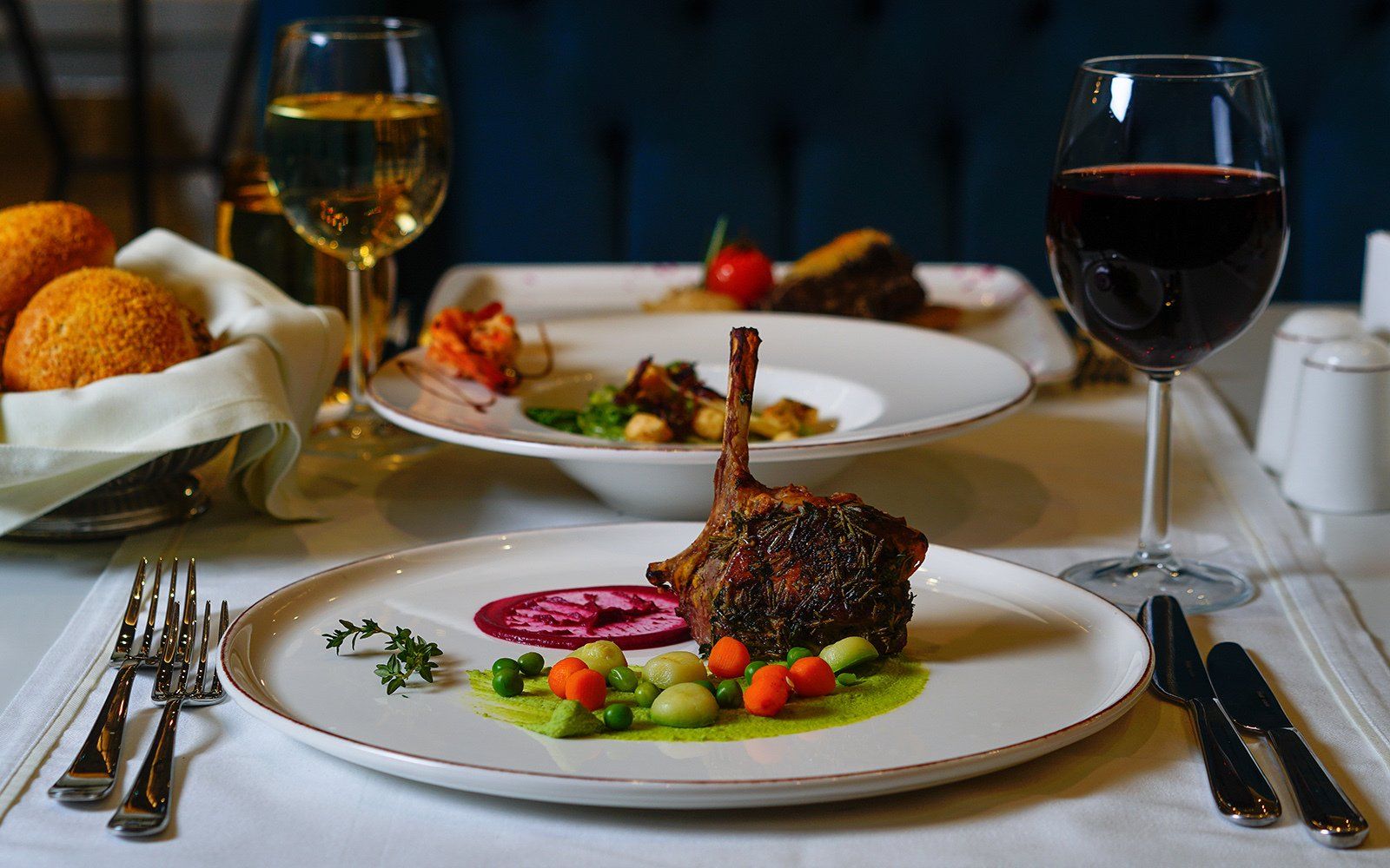 A plate of food and a glass of wine on a table.