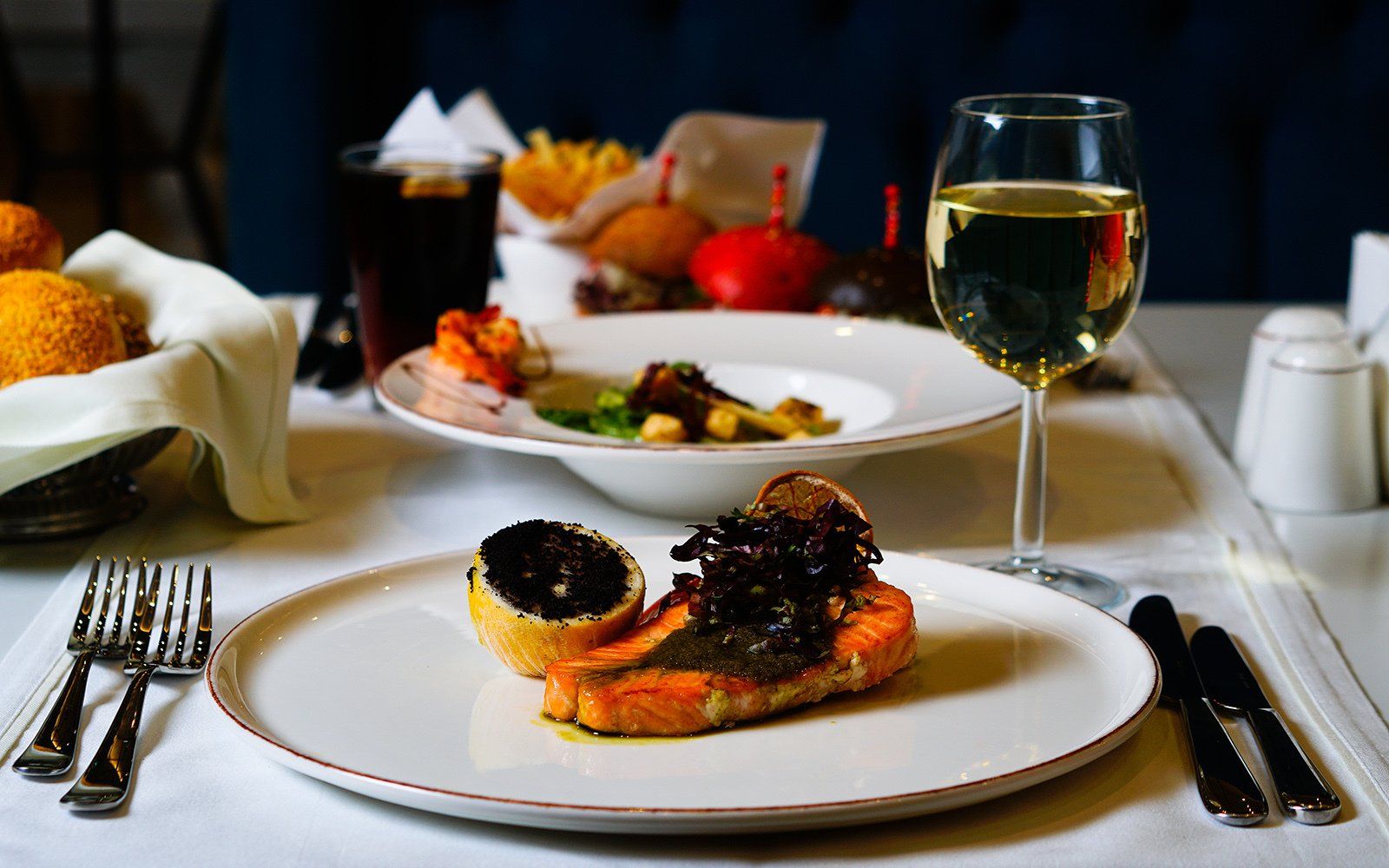 A plate of food and a glass of wine on a table.