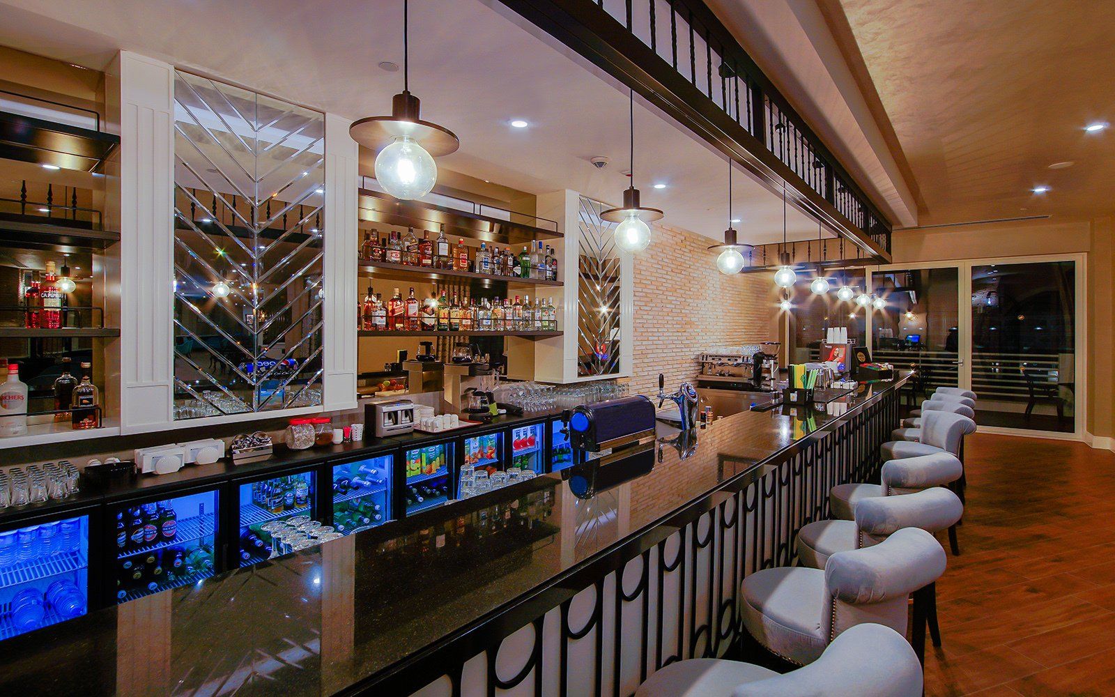 A long bar with a lot of chairs in a restaurant.