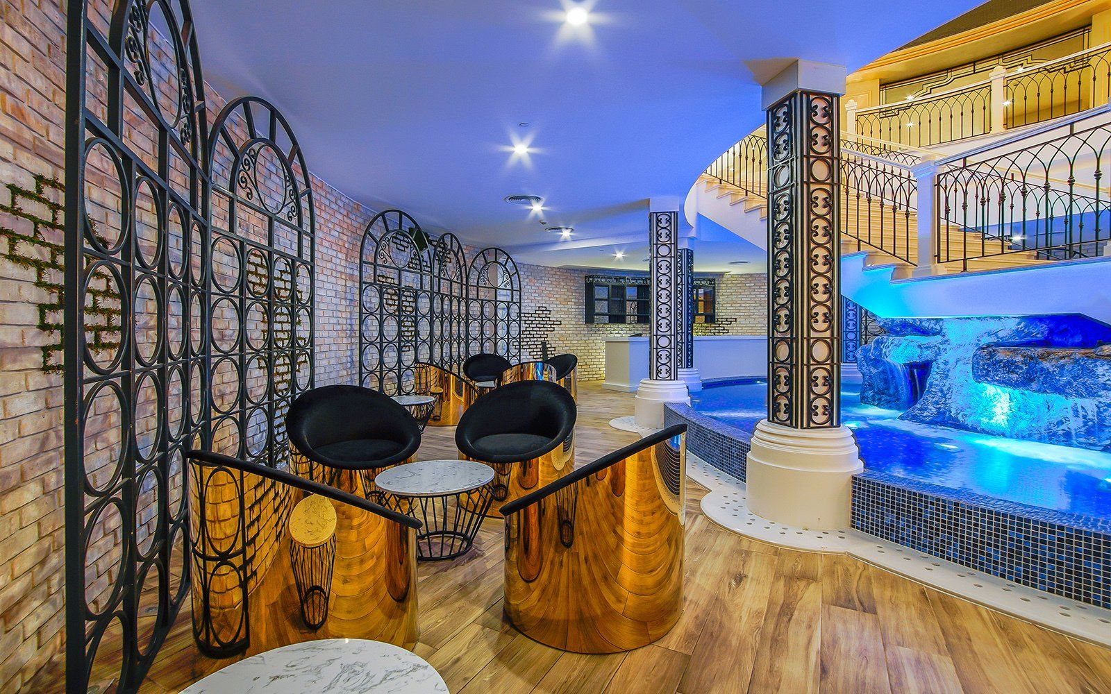 A room with a table and chairs in front of a pool.