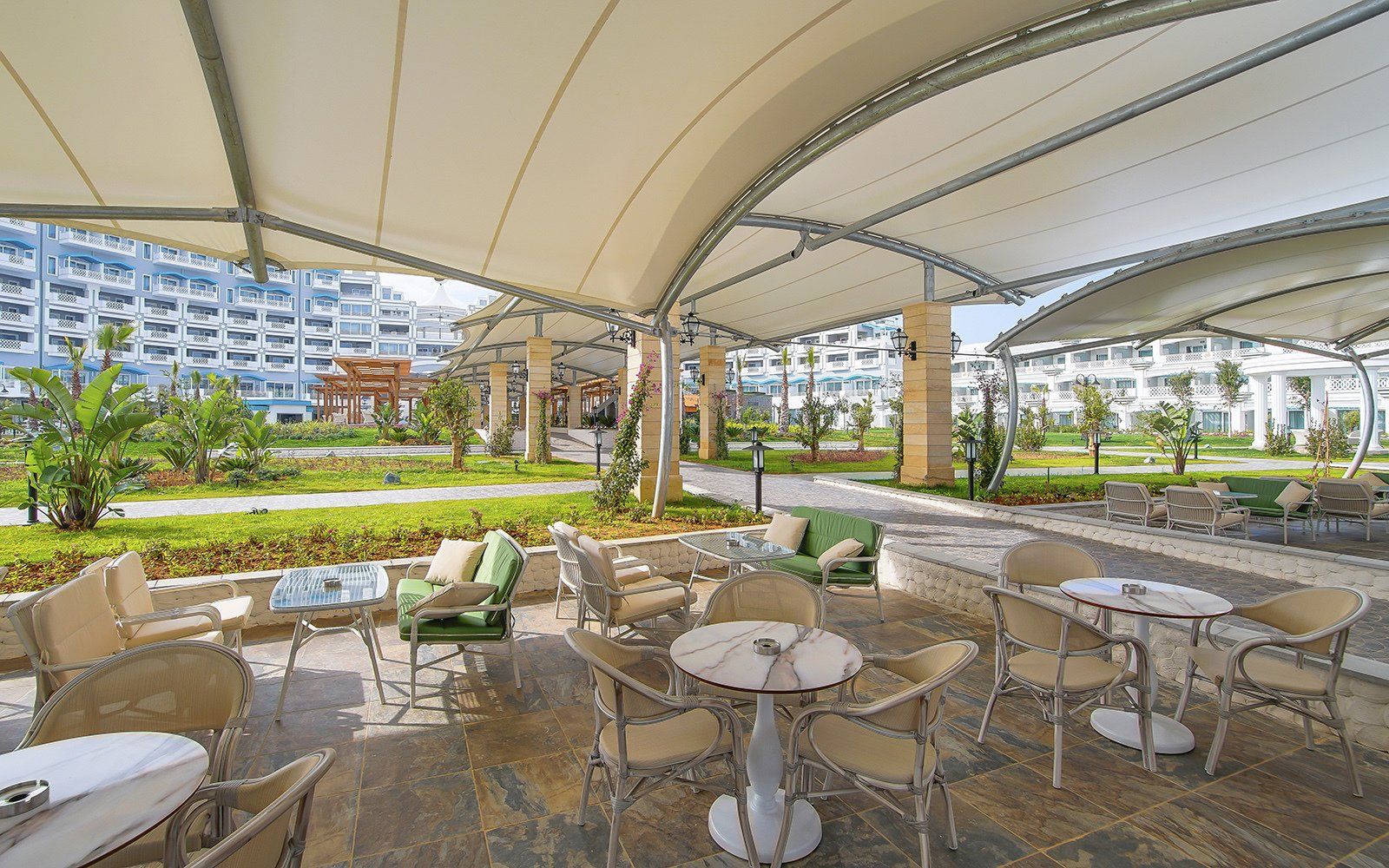 A restaurant with tables and chairs under a canopy.