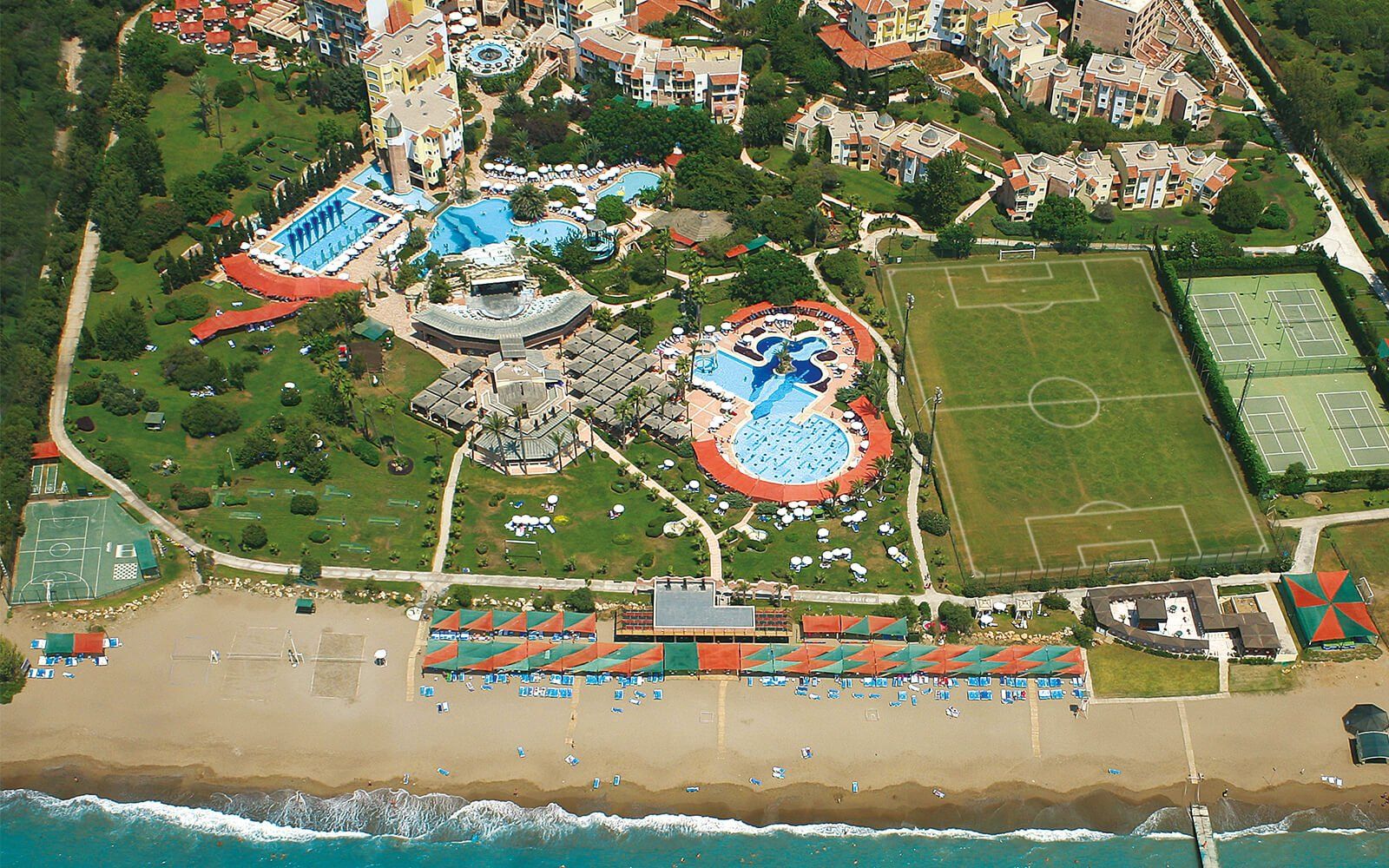 Eine Luftaufnahme eines Resorts mit Strand und Fußballfeldern