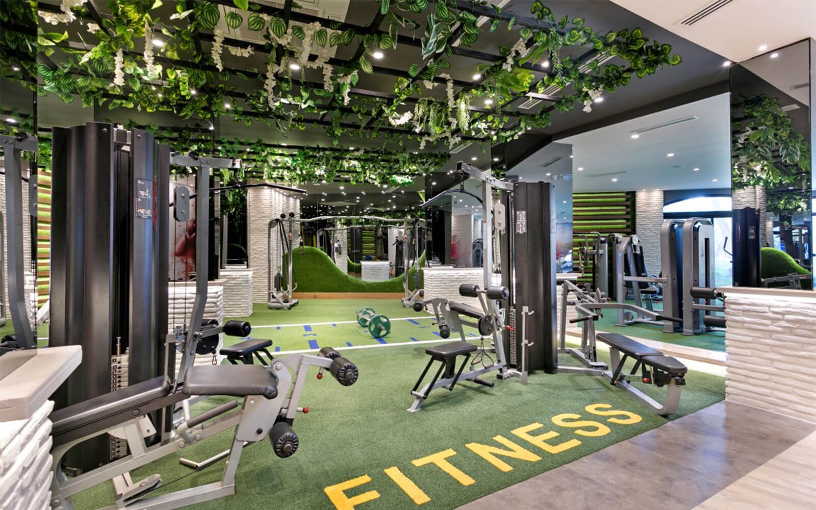 Ein Fitnessstudio mit vielen Geräten und einem Schild mit der Aufschrift „Fitness“ auf dem Boden.
