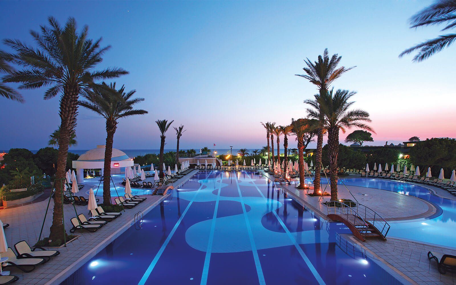 General view of Limak Atlantis De Luxe Hotel & Resort with palm trees and large swimming pools