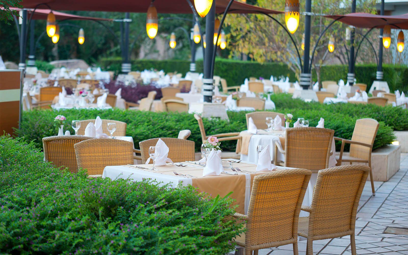 Ein Restaurant mit Tischen und Stühlen im Freien und Sonnenschirmen.