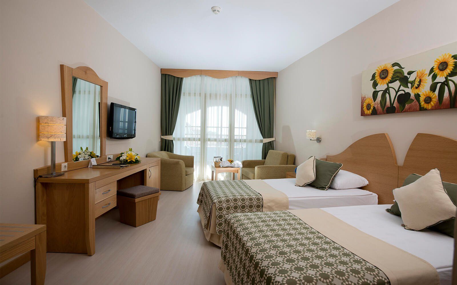 Ein Hotelzimmer mit zwei Betten, einem Schreibtisch und einem Fernseher.