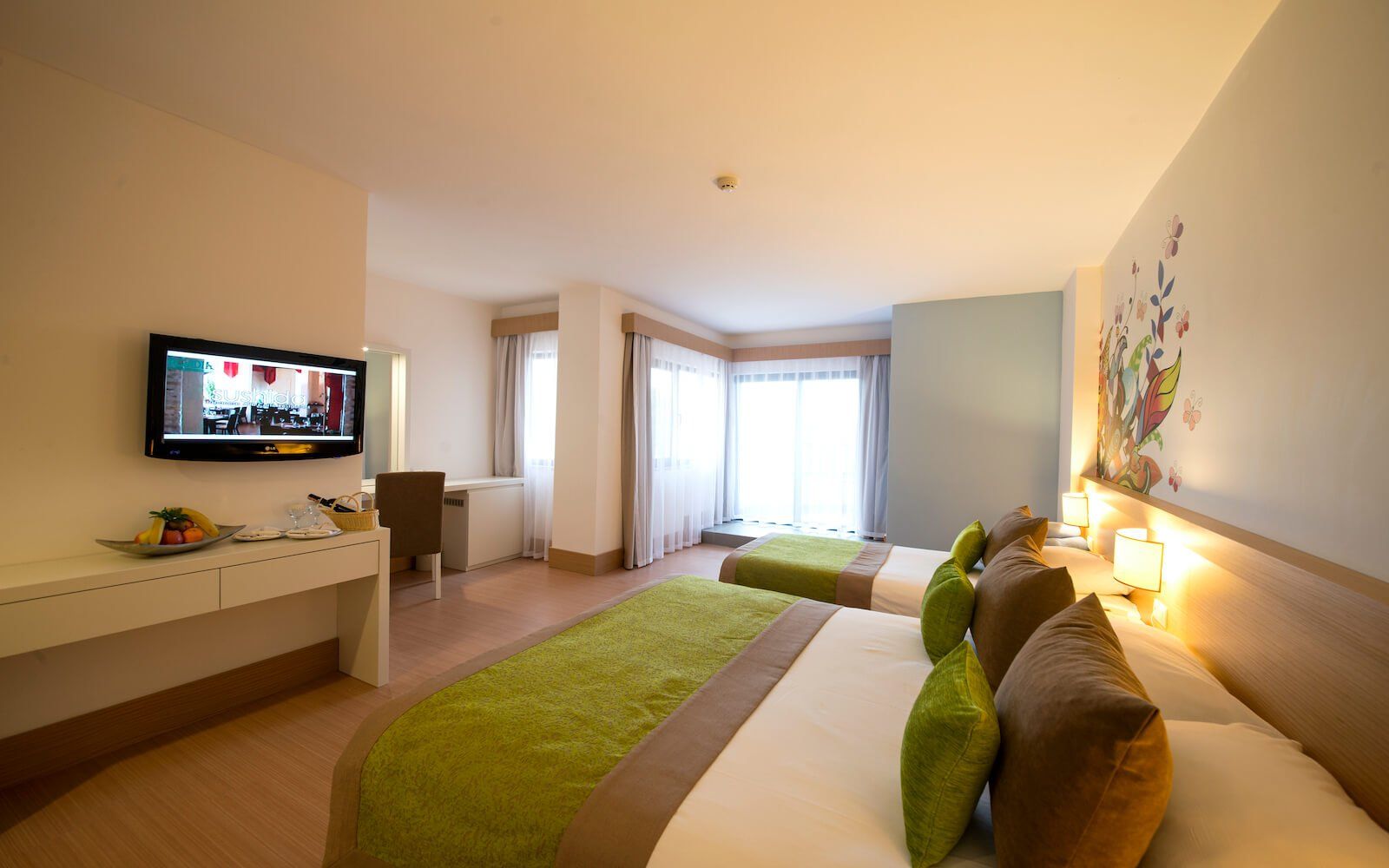 Ein Hotelzimmer mit zwei Betten und einem Flachbildfernseher
