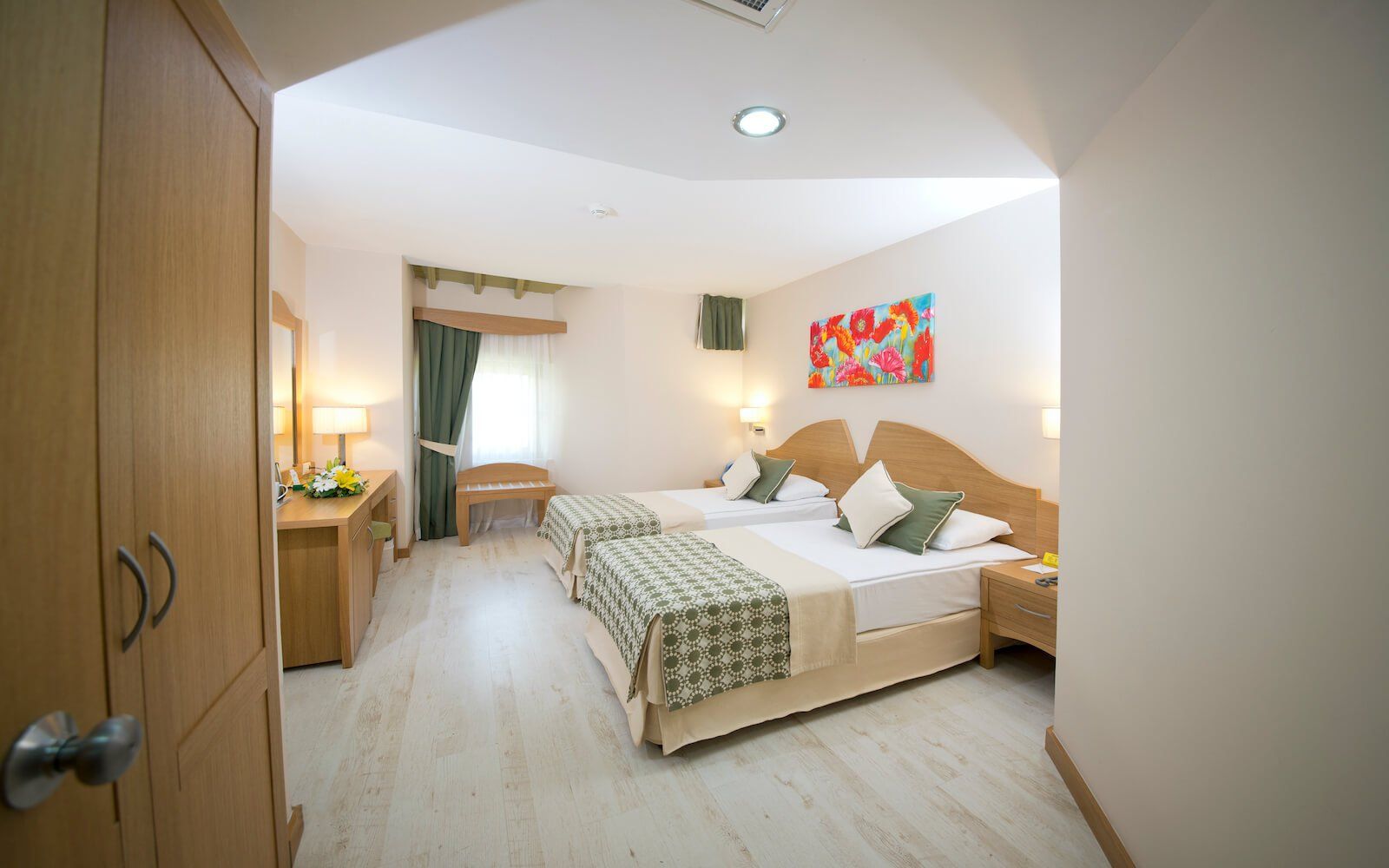 Ein Hotelzimmer mit zwei Betten und einem Gemälde an der Wand.