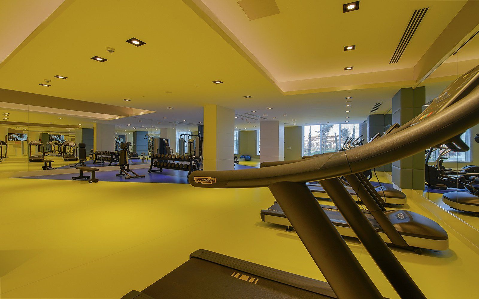 A treadmill is sitting in the middle of a gym.